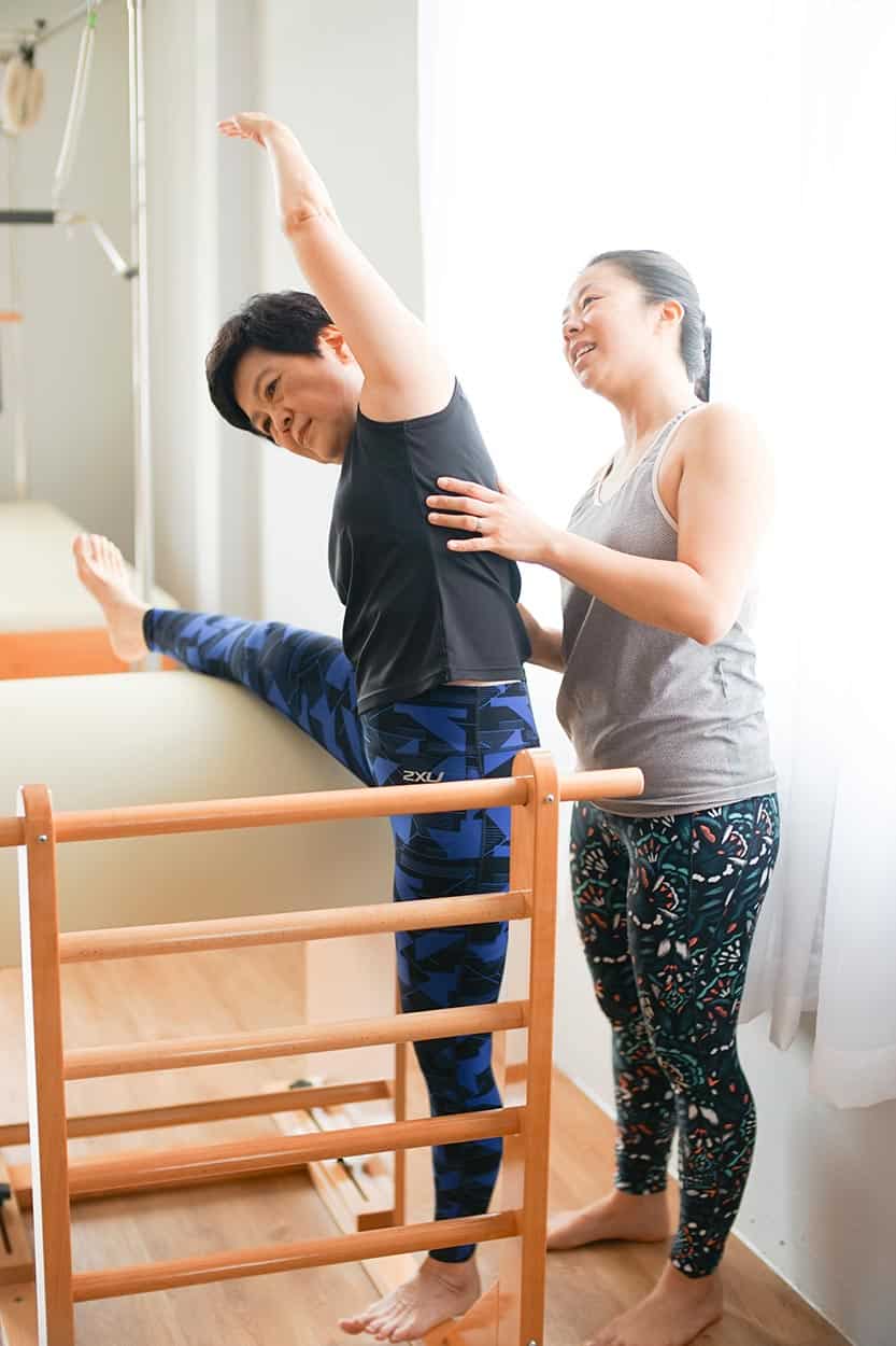 A Clinical Pilates client does a side-bend over the special equipment (called the ladder barrel). The exercise helps mobilise stiff spine segments.